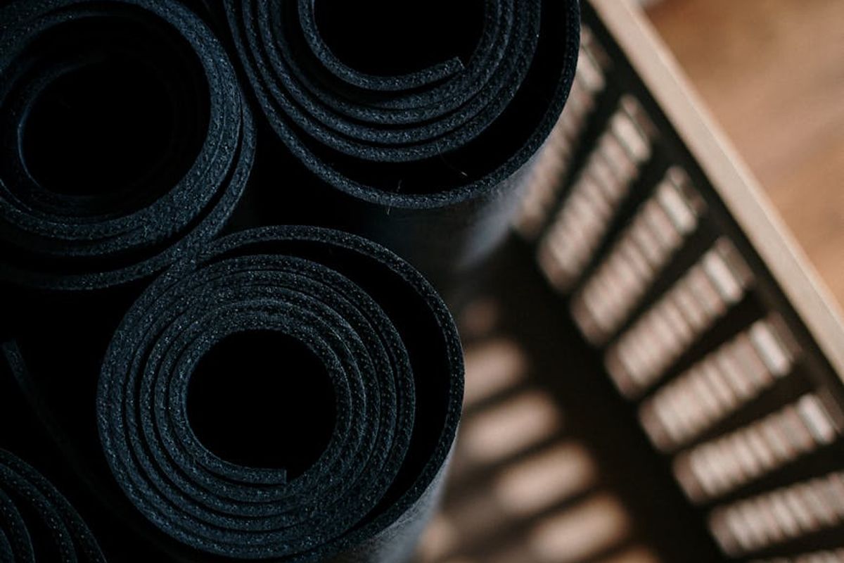 Bright minimal fitness studio with large windows and mats.